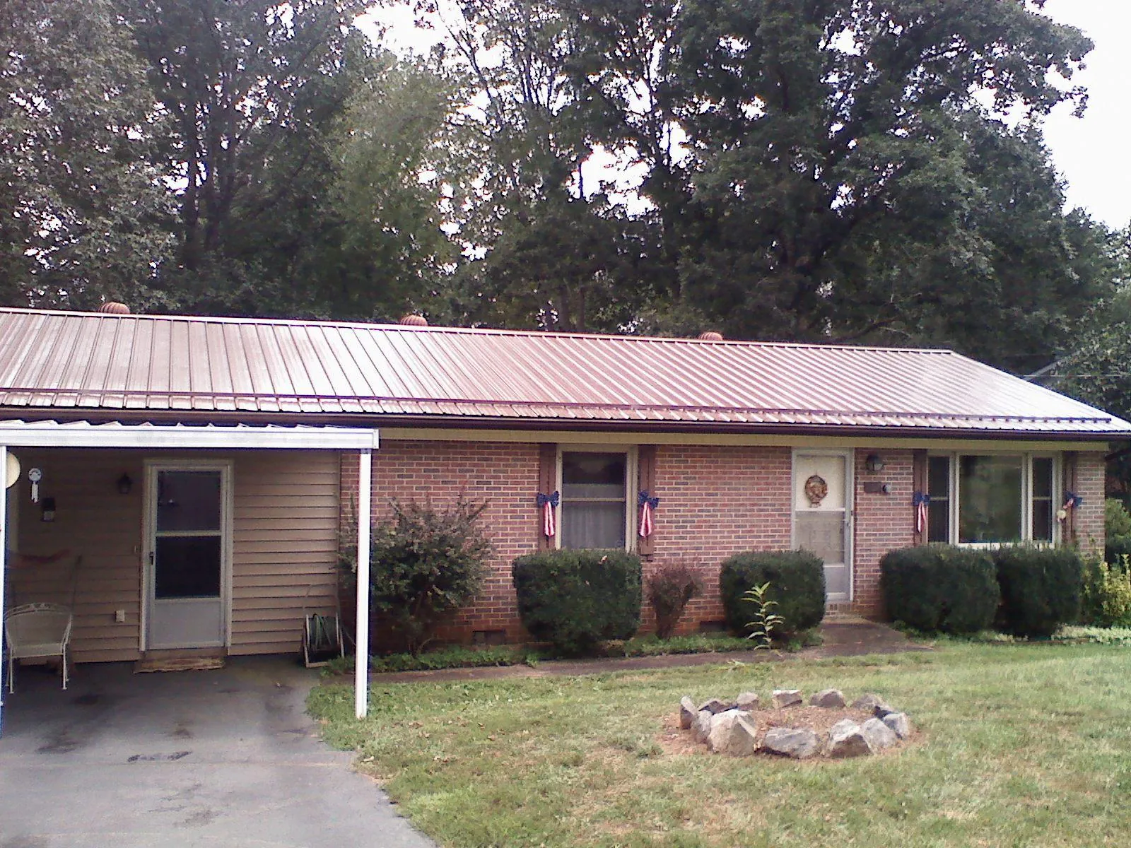 Bronze metal roof and carport on a brick ranch home — Roof Repair work by our crew in Mars
